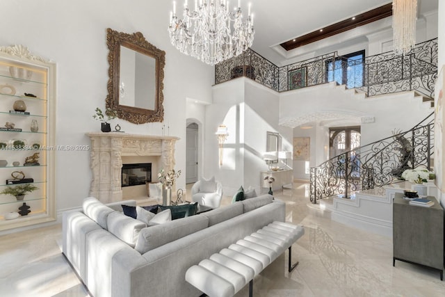 living area with stairs, a chandelier, a fireplace, marble finish floor, and arched walkways