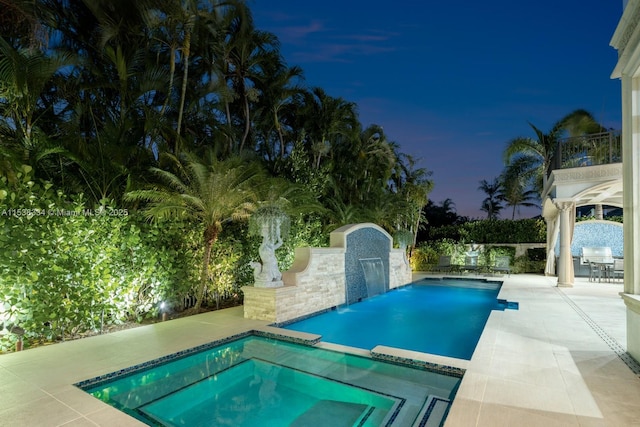 outdoor pool featuring fence, an in ground hot tub, and a patio area