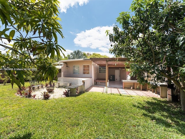 rear view of property with a lawn, a pergola, and a patio