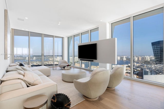 living room with expansive windows and light hardwood / wood-style flooring