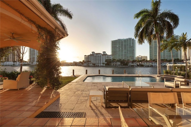 view of pool featuring a patio, a water view, and ceiling fan