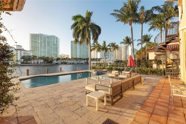 view of swimming pool featuring a patio area, an in ground hot tub, and a water view