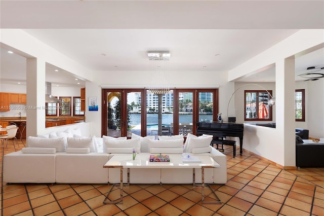 living room featuring sink, light tile patterned floors, and a notable chandelier