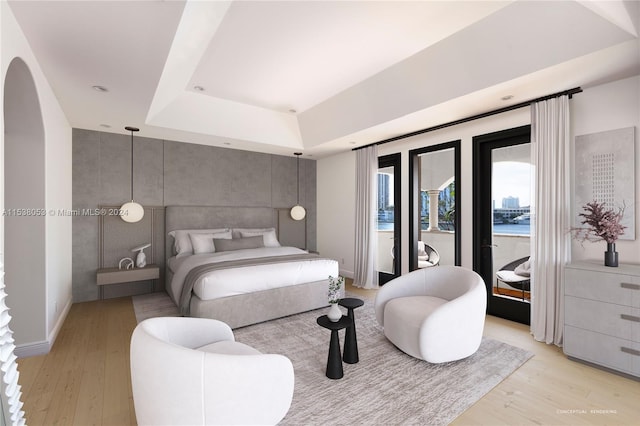 bedroom featuring a raised ceiling and light hardwood / wood-style flooring