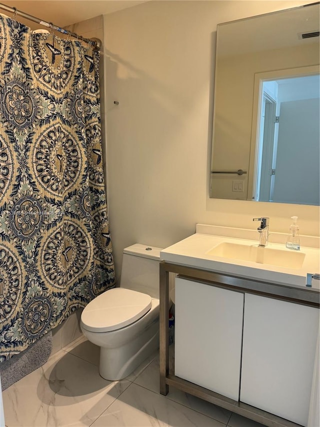 bathroom with tile floors, toilet, and vanity