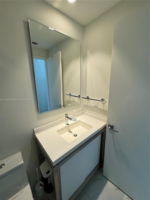 bathroom featuring toilet, tile flooring, and vanity