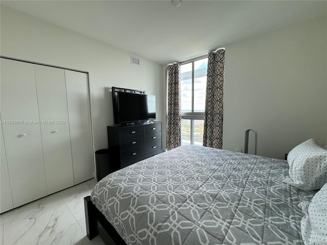 bedroom featuring light tile flooring and a closet