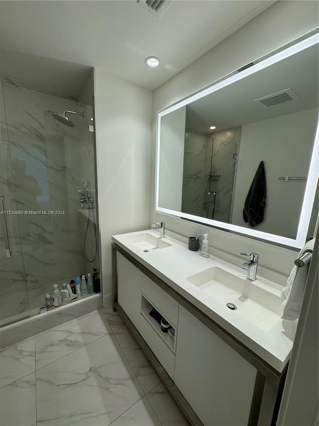 bathroom with tile floors, a shower with shower door, and double vanity