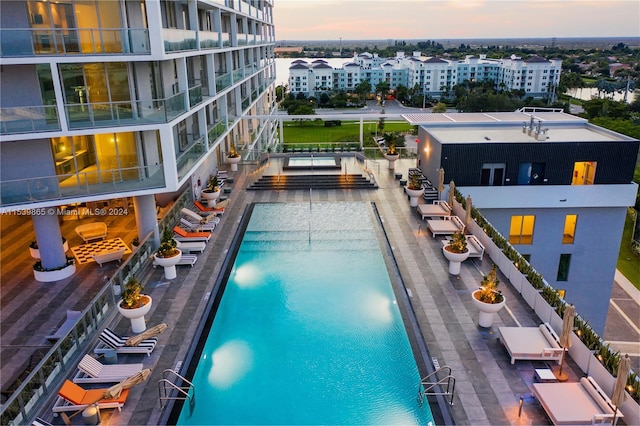 pool at dusk featuring a patio