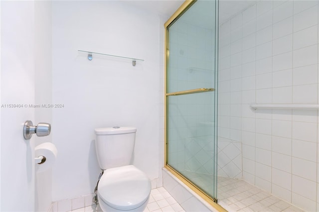 bathroom featuring an enclosed shower, toilet, and tile floors