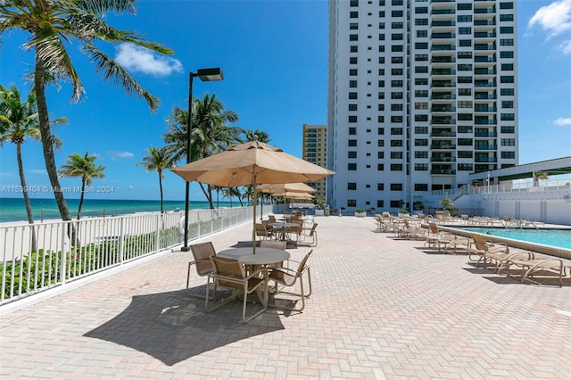 view of patio with a water view and a community pool