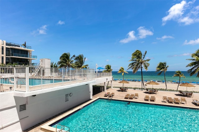 view of swimming pool with a patio and a water view