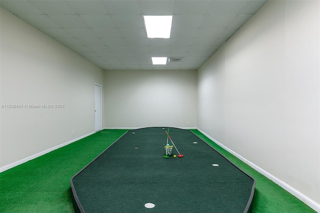 recreation room with dark colored carpet and a drop ceiling