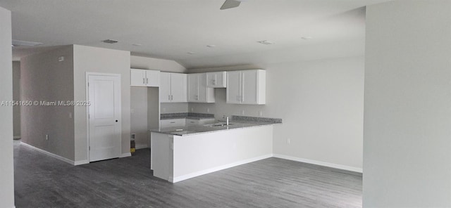 kitchen featuring white cabinetry, dark wood-type flooring, baseboards, and a sink