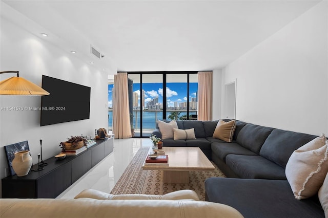 tiled living room with a water view and a wall of windows