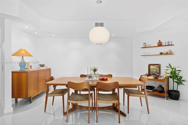 tiled dining room with a raised ceiling