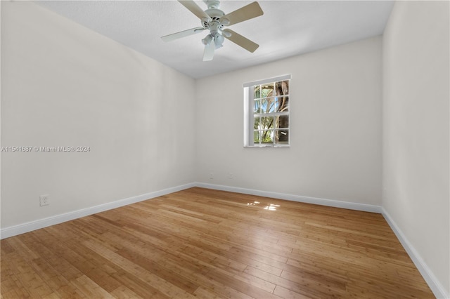 empty room with ceiling fan and light hardwood / wood-style flooring