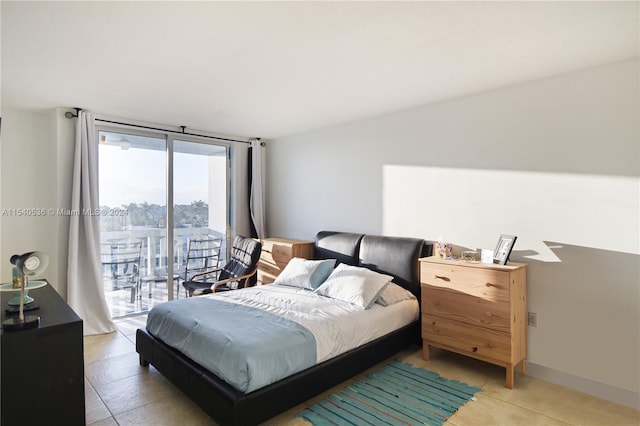 tiled bedroom featuring expansive windows and access to exterior