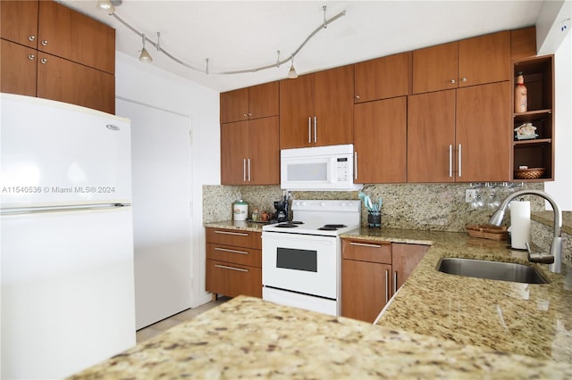 kitchen with tasteful backsplash, white appliances, rail lighting, and sink