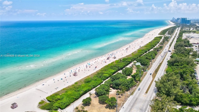 birds eye view of property with a water view and a beach view