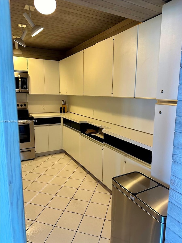 kitchen featuring white cabinetry, track lighting, stainless steel appliances, light tile floors, and wood ceiling