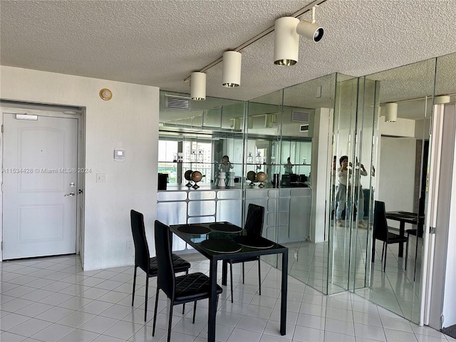 dining room with a textured ceiling and light tile floors