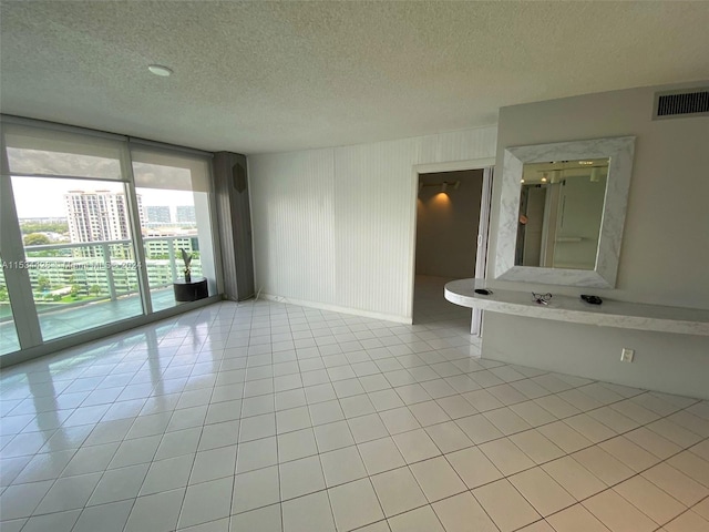 unfurnished bedroom featuring a textured ceiling, light tile floors, and access to exterior