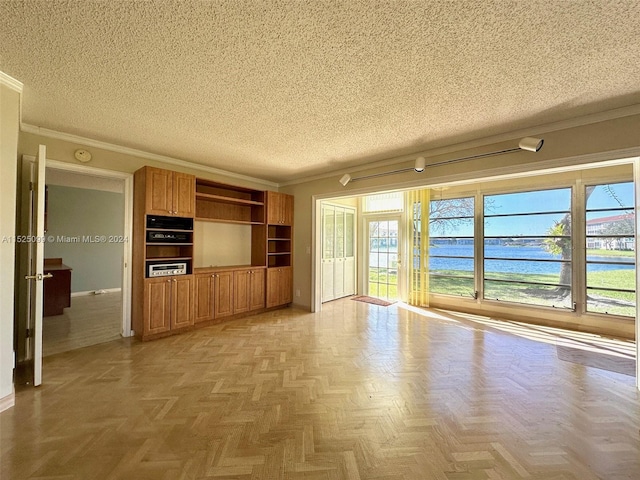 unfurnished living room with ornamental molding, a textured ceiling, light parquet flooring, and a water view