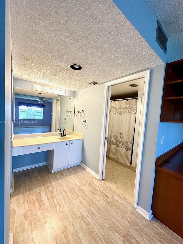 bathroom featuring tile flooring, vanity, and a textured ceiling