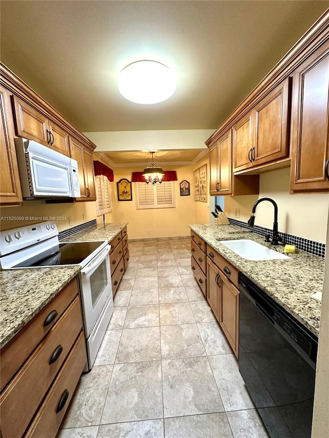 kitchen featuring white appliances, an inviting chandelier, light stone counters, light tile floors, and sink