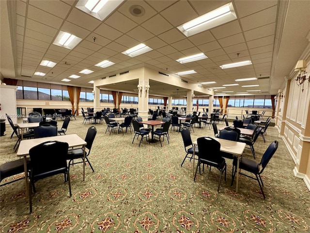 dining area featuring a wealth of natural light, carpet floors, and a drop ceiling