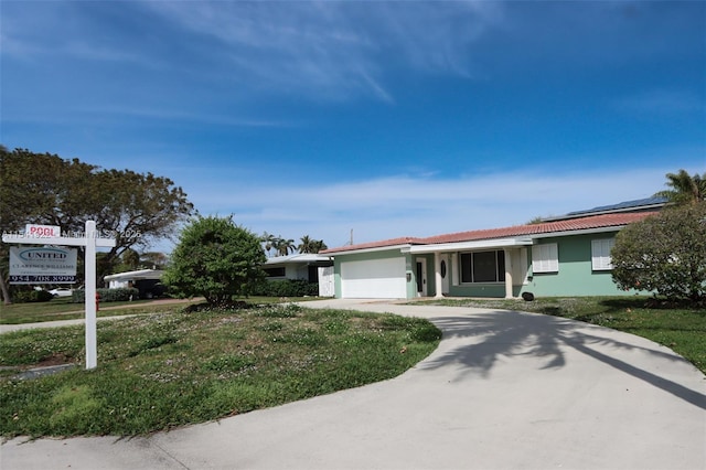 ranch-style home with a garage and a front yard