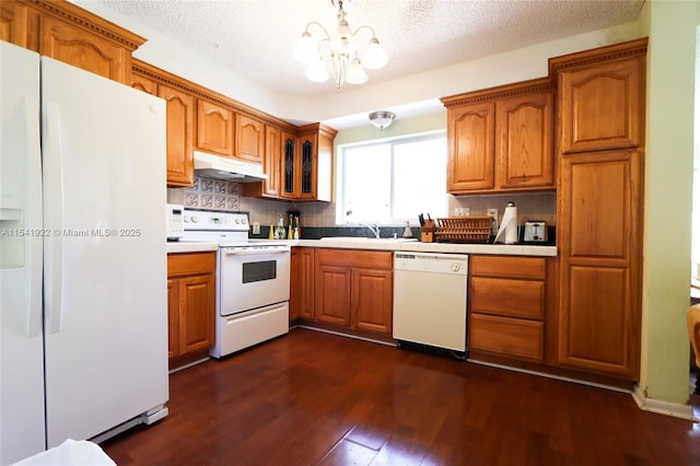 kitchen featuring tasteful backsplash, a textured ceiling, white appliances, a notable chandelier, and dark hardwood / wood-style floors