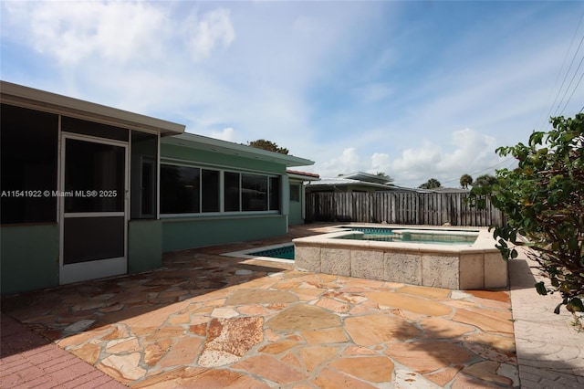 view of swimming pool with a sunroom, a patio area, and an in ground hot tub