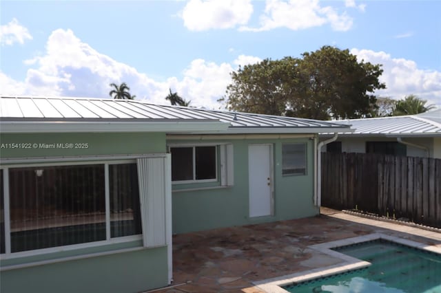 back of house with a patio, metal roof, a standing seam roof, and fence