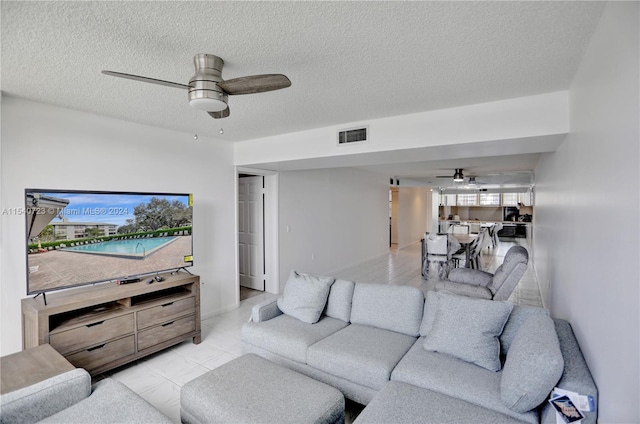 tiled living room featuring a textured ceiling and ceiling fan