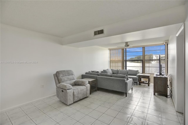 tiled living room with expansive windows and ceiling fan