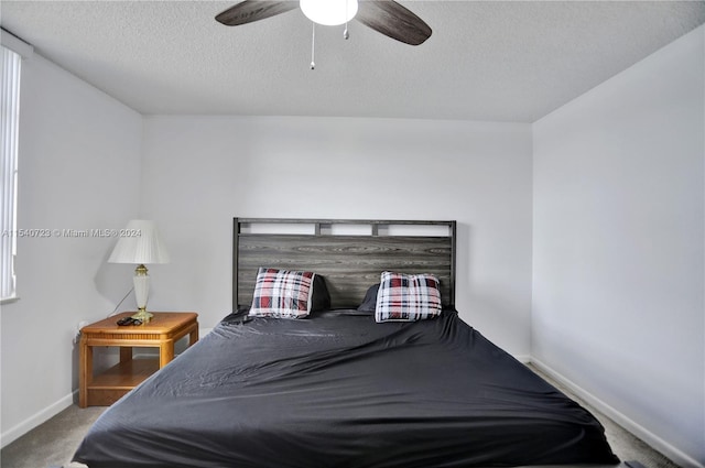 bedroom featuring carpet floors, a textured ceiling, and ceiling fan