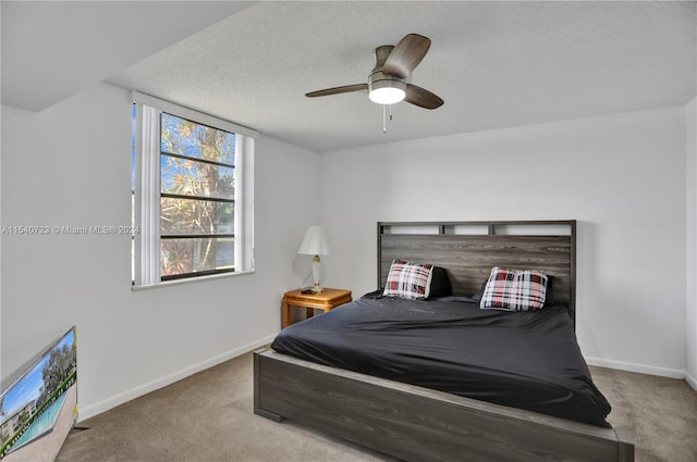 carpeted bedroom with ceiling fan and a textured ceiling