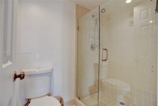 bathroom with toilet and a shower with door