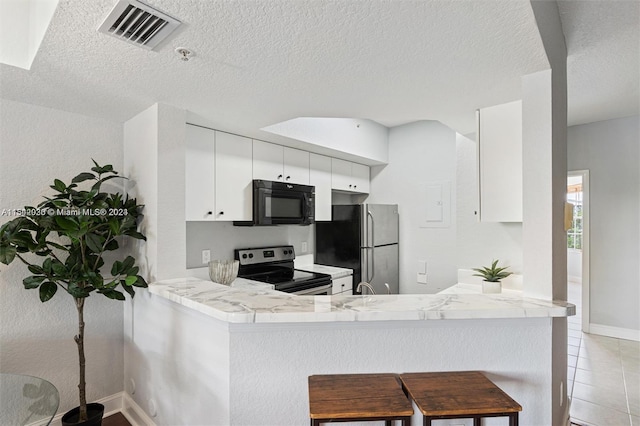 kitchen with kitchen peninsula, white cabinets, a textured ceiling, and appliances with stainless steel finishes