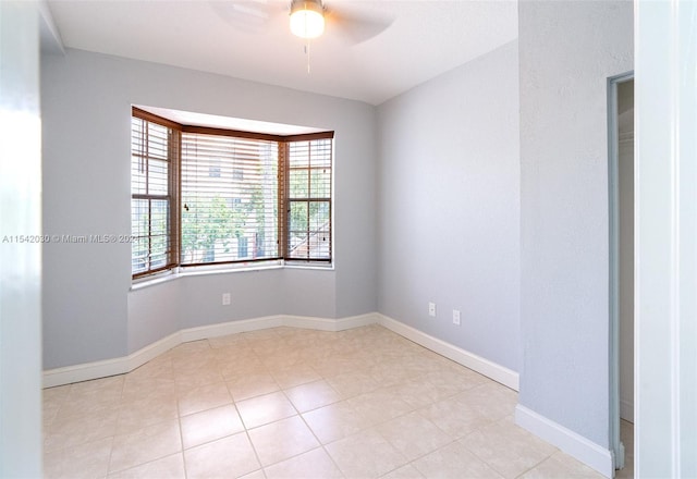 tiled empty room featuring ceiling fan