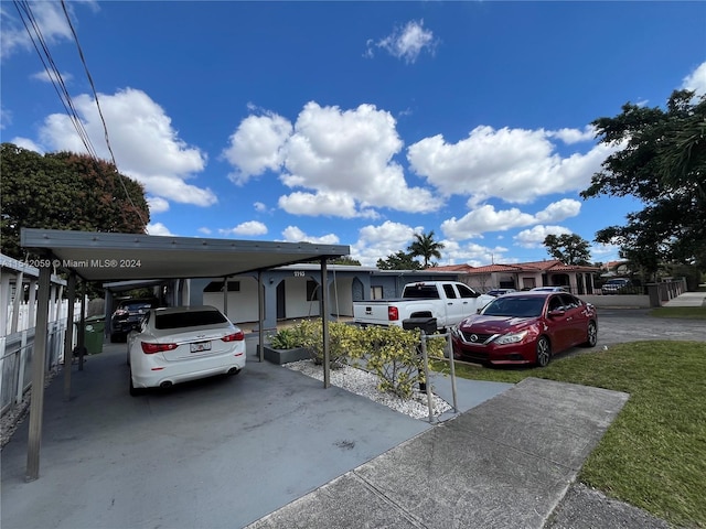 view of car parking featuring a lawn and a carport