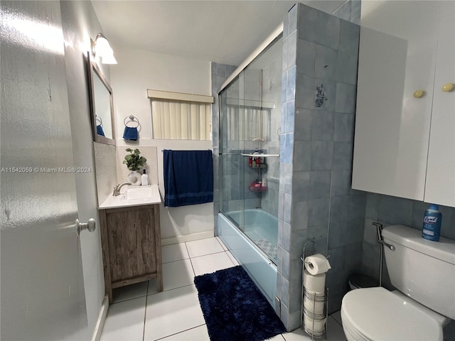 bathroom with vanity, tile floors, toilet, and tile walls