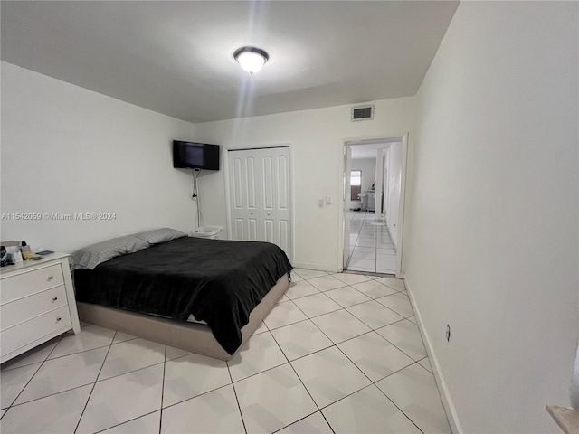 bedroom featuring light tile floors and a closet