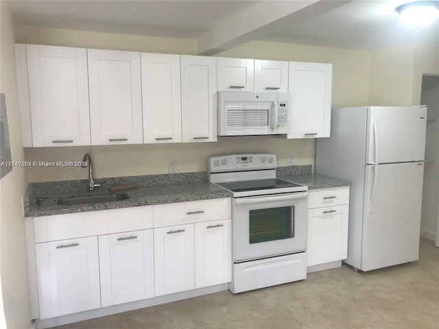 kitchen with white cabinets, dark stone counters, white appliances, and sink