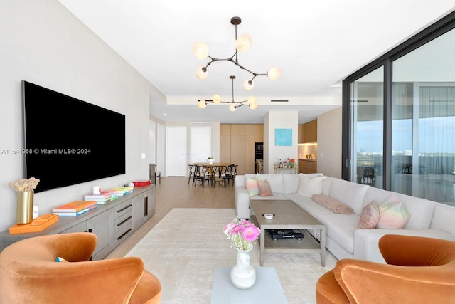 living room with a chandelier and light wood-type flooring