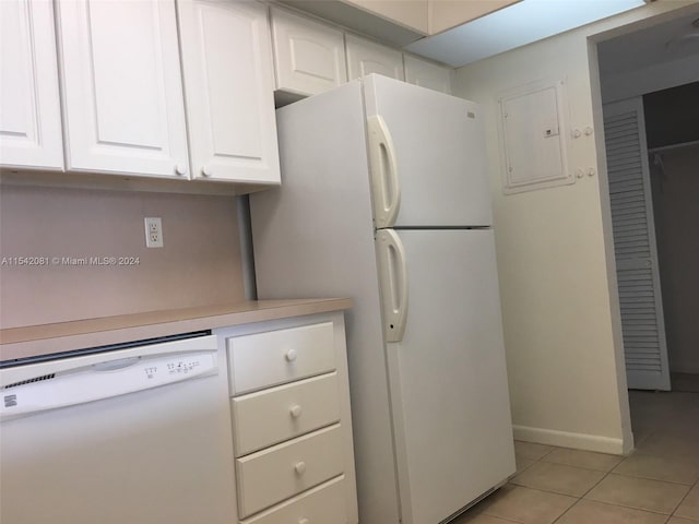 kitchen featuring white appliances, white cabinets, and light tile floors