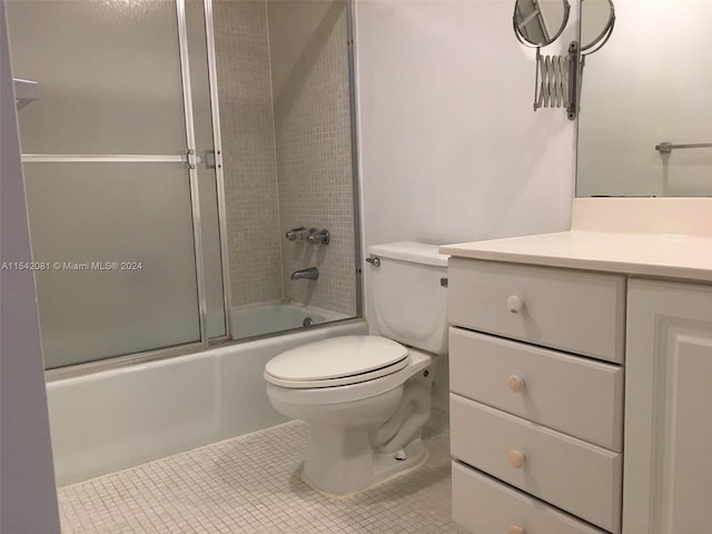 full bathroom featuring vanity, tile floors, toilet, and enclosed tub / shower combo