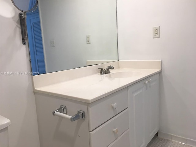 bathroom featuring toilet, tile floors, and vanity